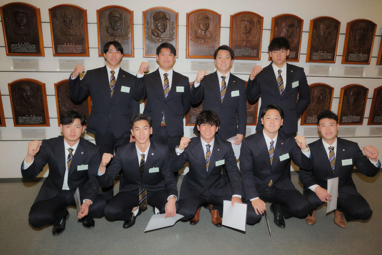 吉田義男氏のレリーフの前で写真に納まる阪神伊原（前列中央）ら。手前左から町田、今朝丸、1人おいて木下、佐野、後方左から工藤、嶋村、川崎、早川（撮影・河田真司）