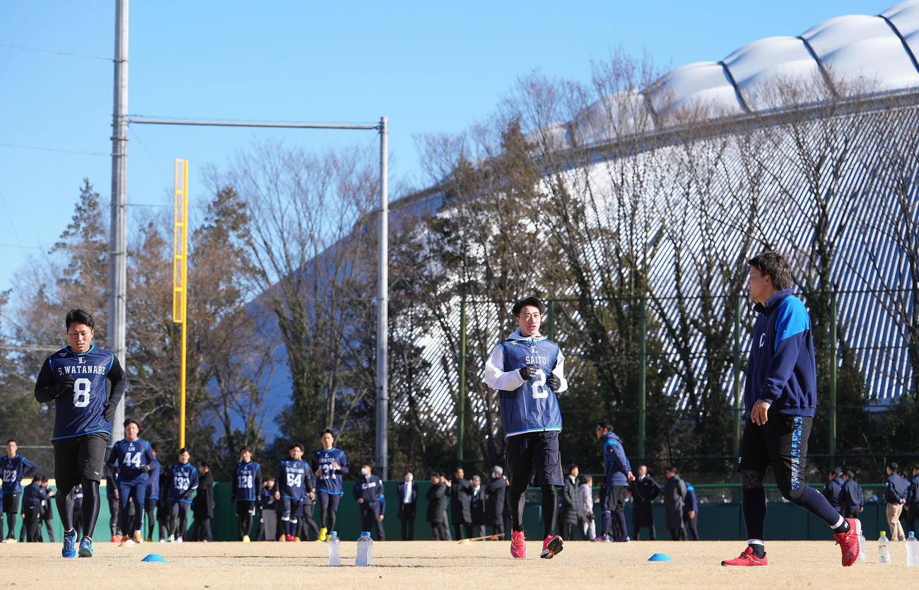 ベルーナドームを背に新人合同自主トレーニングに臨む西武ドラフト1位金沢高・斎藤（中央）、同2位大商大・渡部聖（左）ら（撮影・足立雅史）