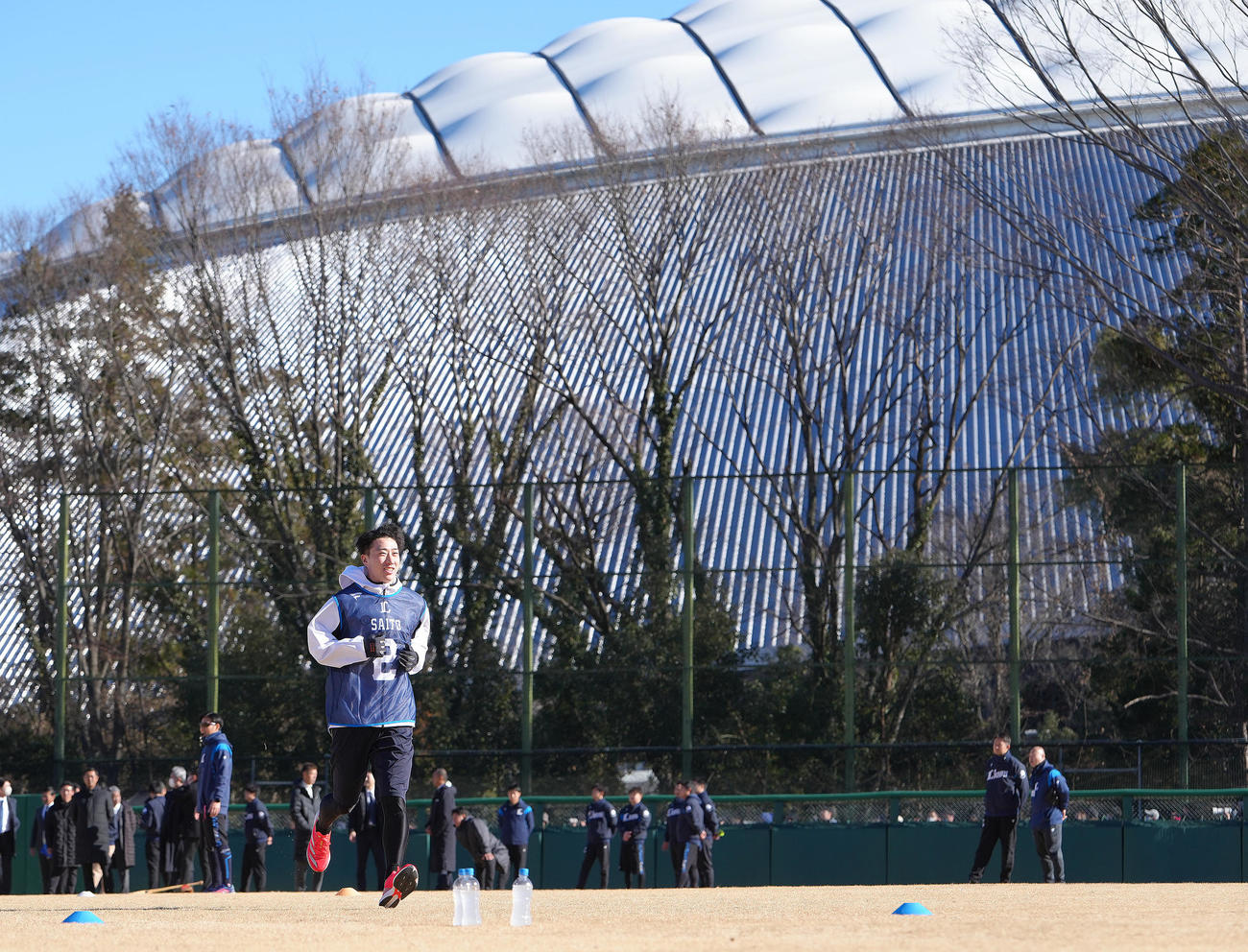 ベルーナドームを背に新人合同自主トレーニングに臨む西武ドラフト1位金沢高・斎藤（撮影・足立雅史）