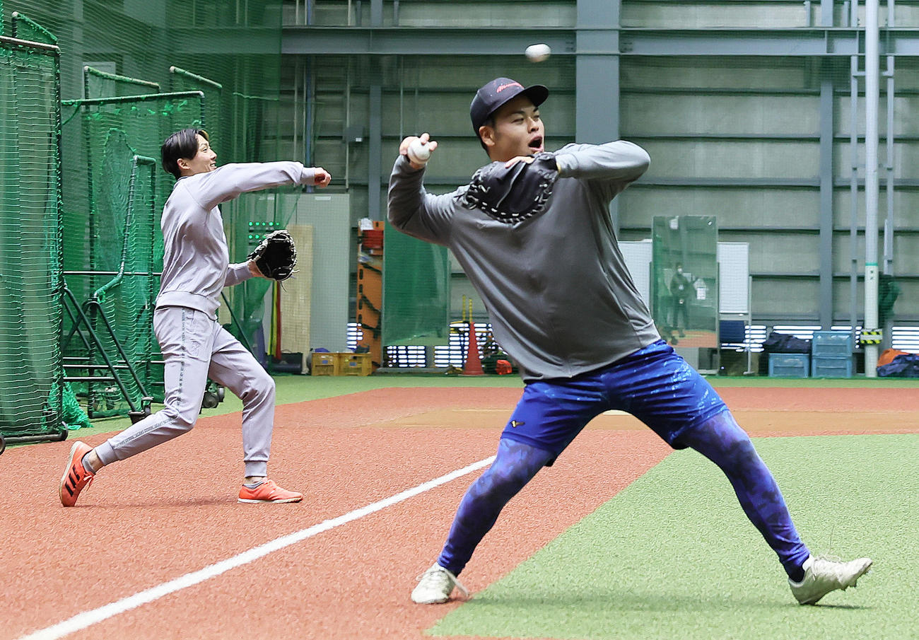 自主トレのキャッチボール中、西武是沢（右）の声出しに笑顔を見せる源田（撮影・足立雅史）