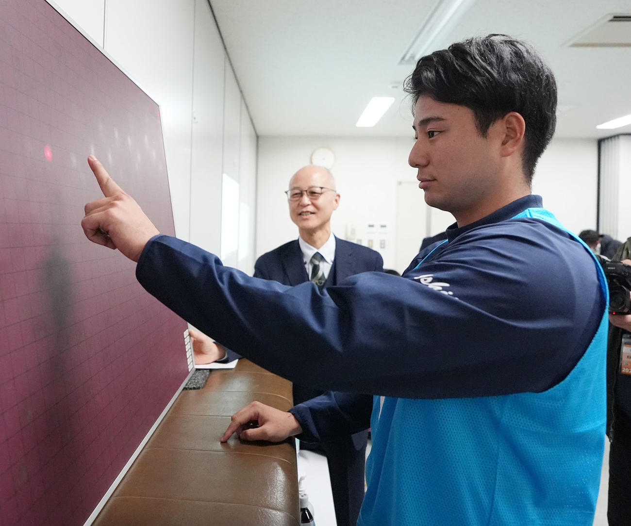 自主トレ後、視力測定を行う石伊（撮影・森本幸一）