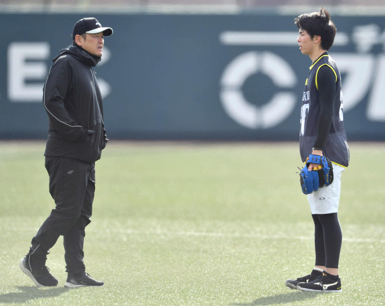 新人合同自主トレを視察した倉野コーチ（左）は村上と話す（撮影・岩下翔太）