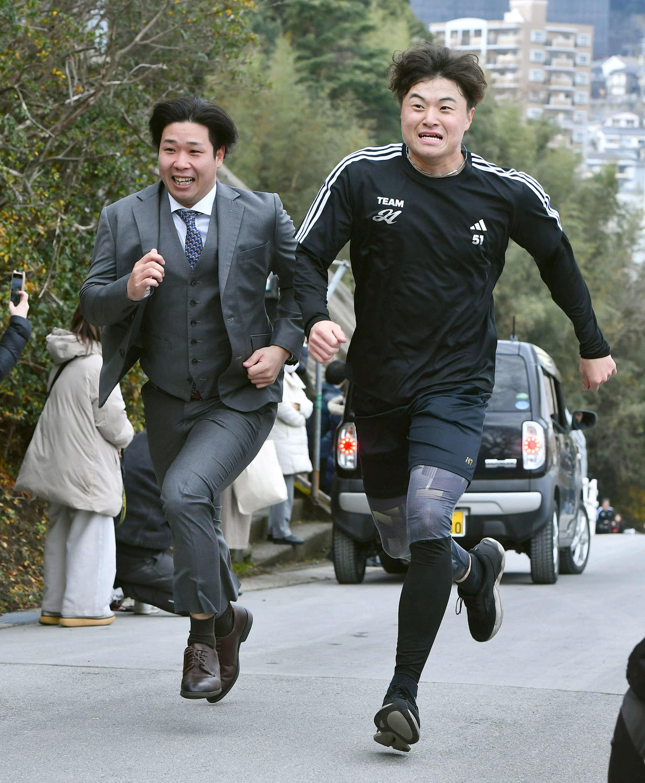 今年からソフトバンク球団広報転身した鍬原拓也さん（左）と長崎県護国神社への坂を駆け上がるソフトバンク前田純（撮影・岩下翔太）
