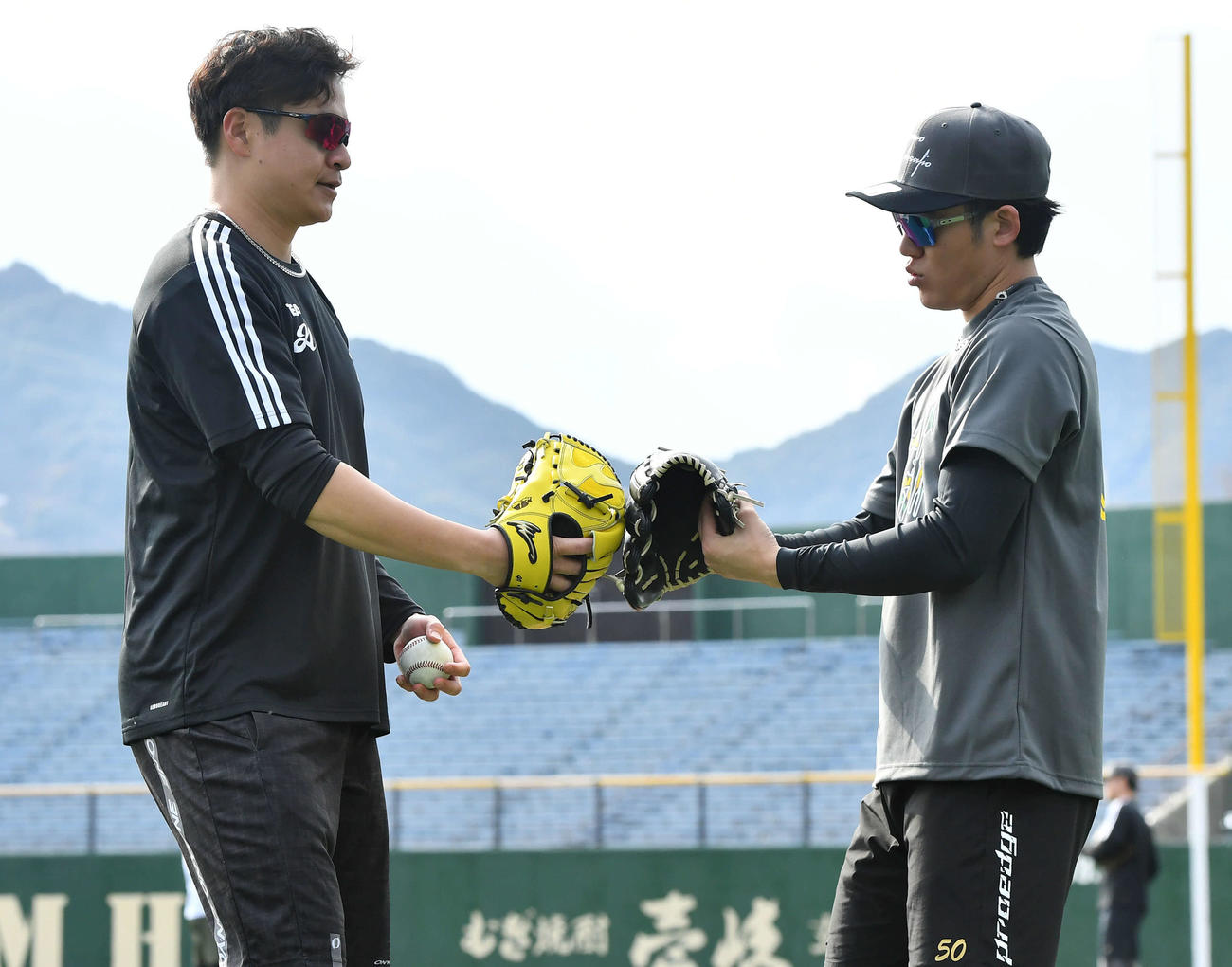 キャッチボールを終えてグラブタッチを交わす阪神大竹（左）と富田（撮影・岩下翔太）