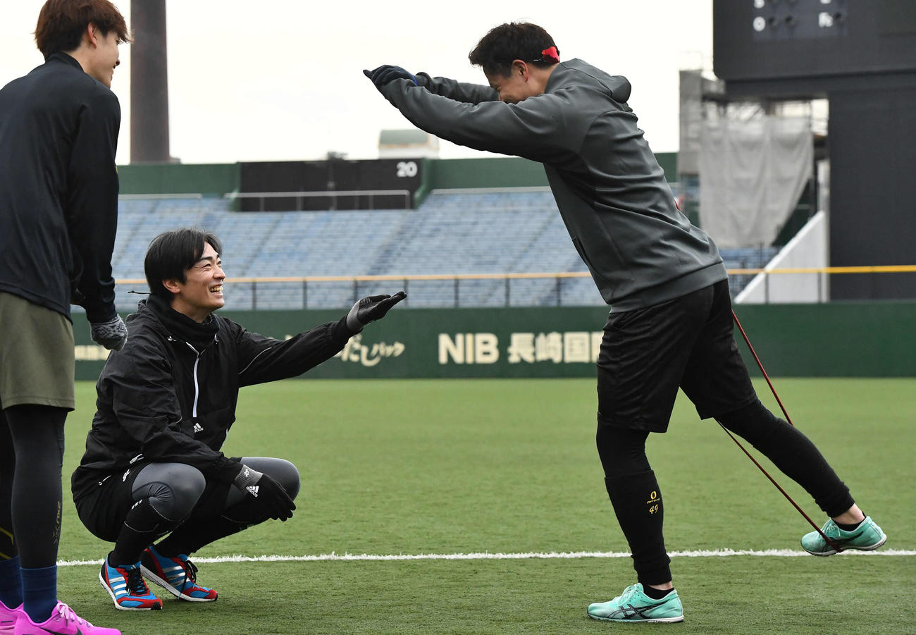 和田毅氏（左から2人目）と笑顔でトレーニングを行う阪神大竹（撮影・岩下翔太）
