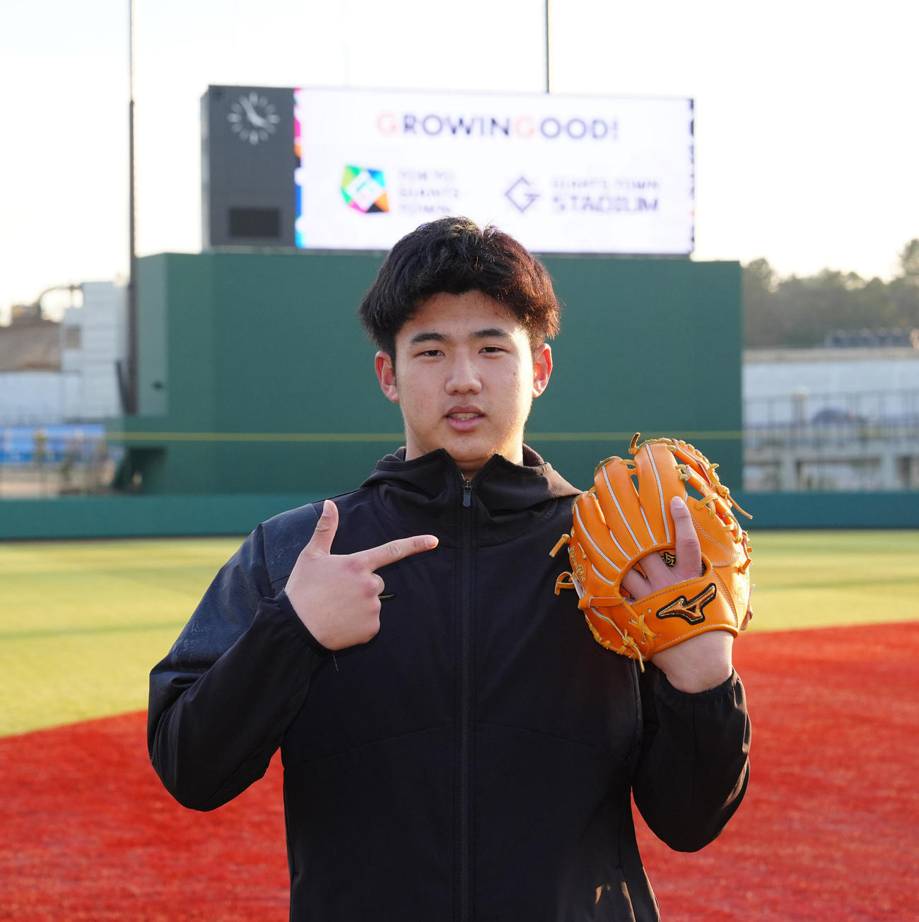 巨人新人合同自主トレ後、グラブを手に写真に納まる石塚（撮影・江口和貴）
