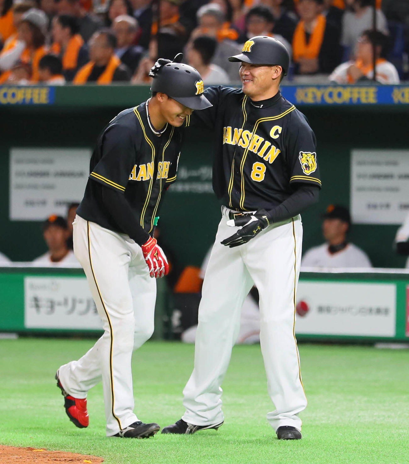2018年3月30日、大山は右越え2点本塁打を放ち、一塁走者の福留（右）に頭をたたかれる