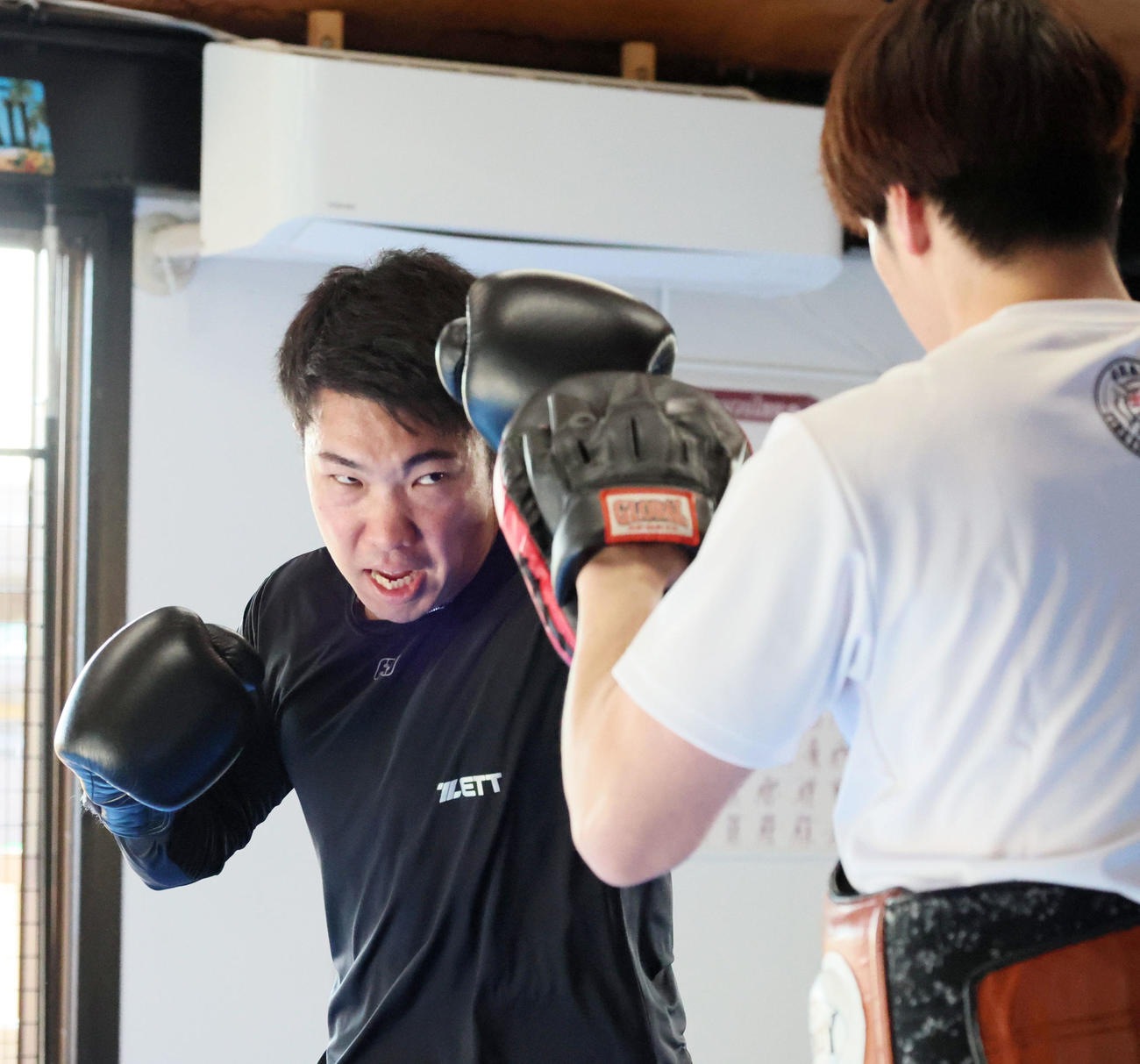 自主トレを公開し金谷トレーナー（右）とミット打ちを行う石井（撮影・加藤哉）