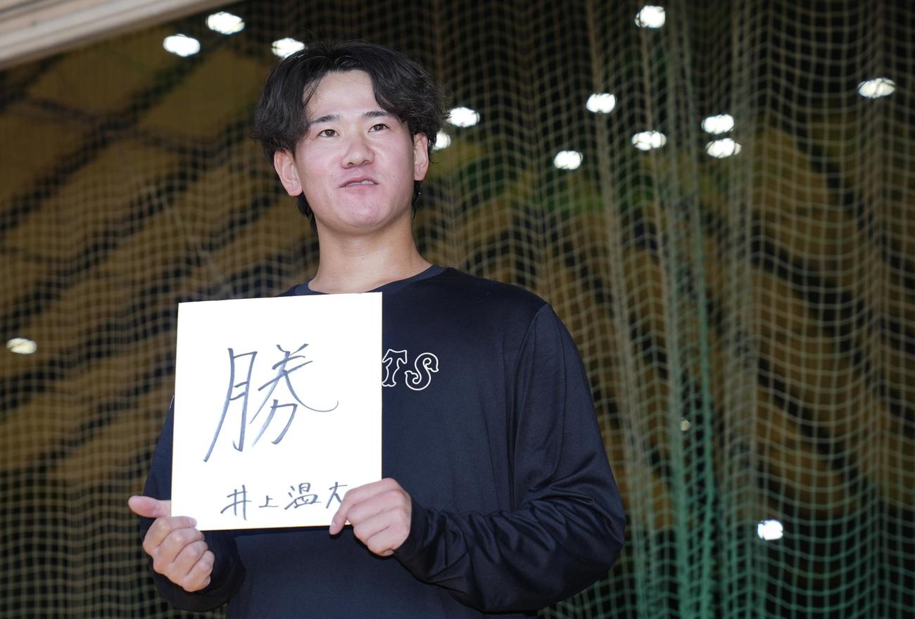 自主トレを終え今年の漢字を色紙に記した巨人井上（撮影・垰建太）