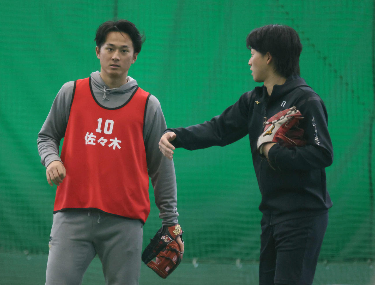 合同自主トレで話し合うドラフト1位の佐々木（左）と常広（撮影・加藤孝規）