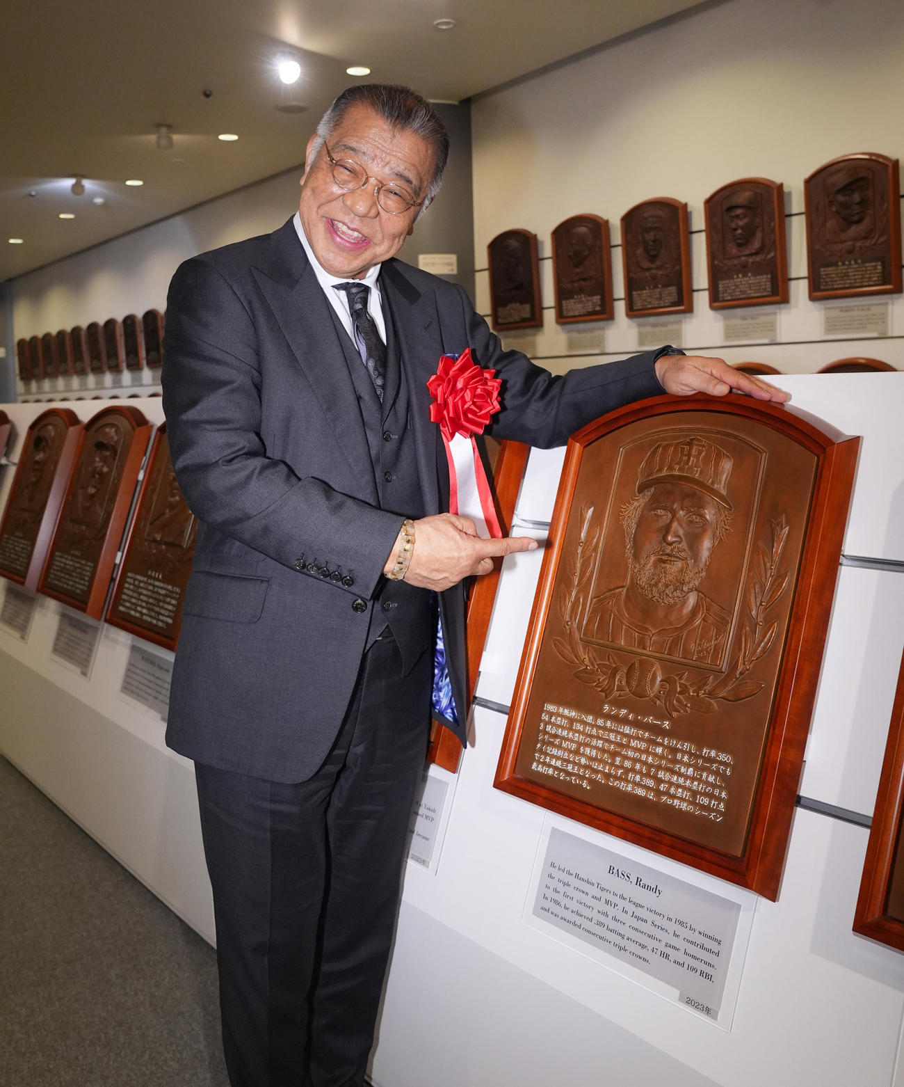 野球殿堂入り通知式を終えバース氏のレリーフと笑顔で写真に納まる掛布氏（撮影・垰建太）