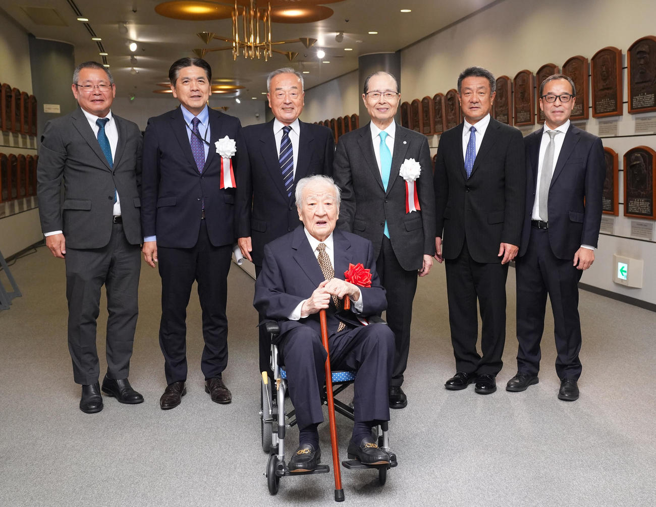 野球殿堂入り通知式で王氏（後方中央右）ら関係者と記念写真に納まる富沢氏（手前）（撮影・垰建太）