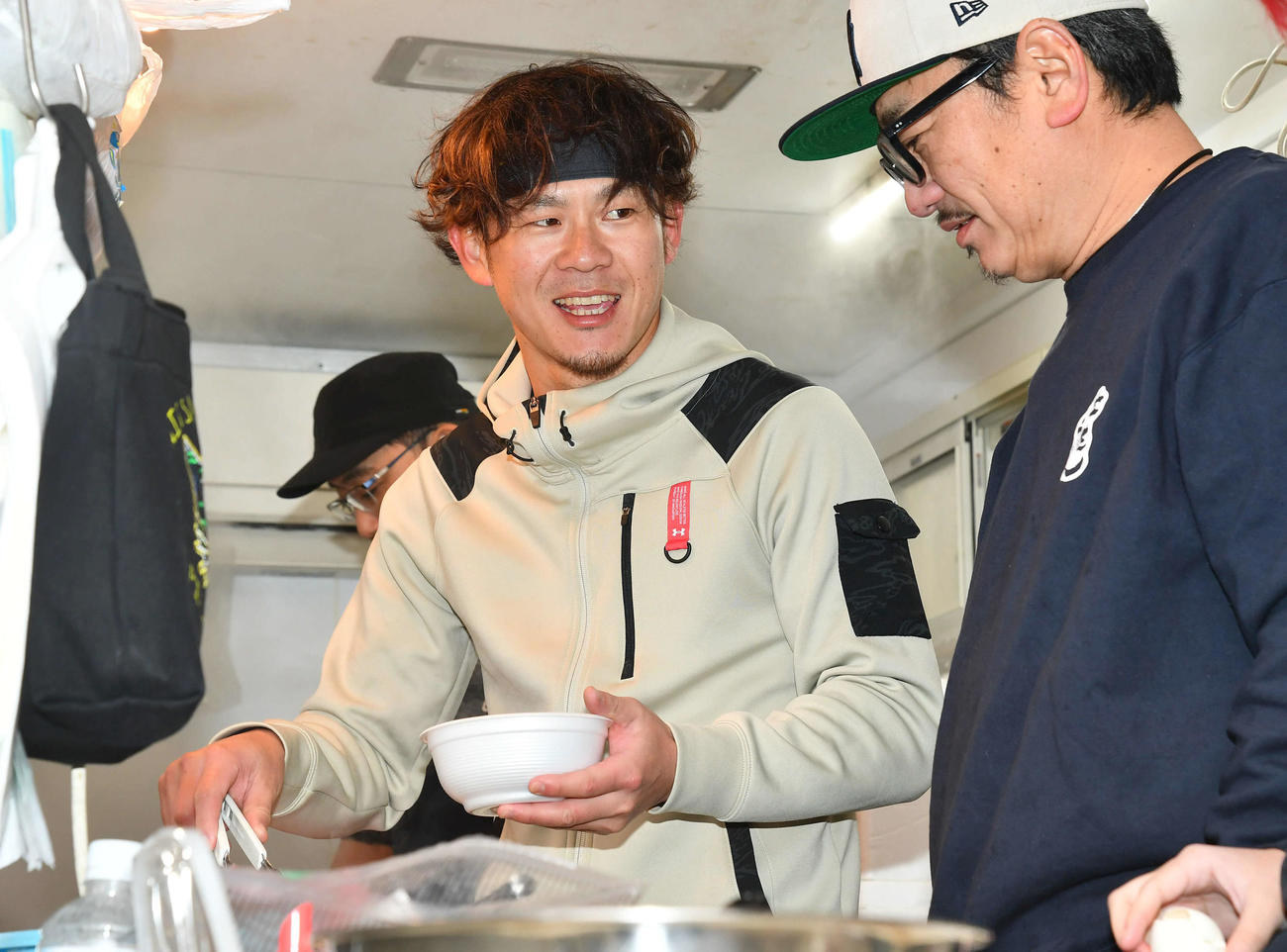 キッチンカーでうどんを盛りつけるソフトバンク牧原大（撮影・岩下翔太）