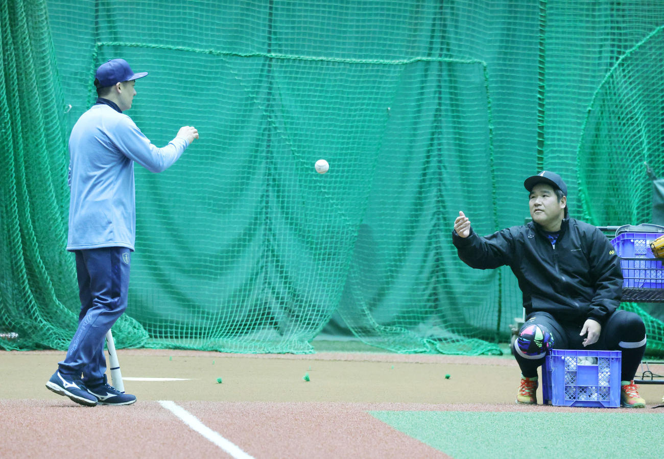 自主トレを公開しノックする西武栗山（左）に球を渡す中村剛（撮影・鈴木正人）