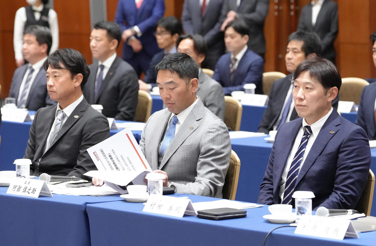 巨人スタッフ会議を前に、資料に目を通す阿部監督（中央）。左は二岡コーチ、右は村田コーチ（撮影・足立雅史）