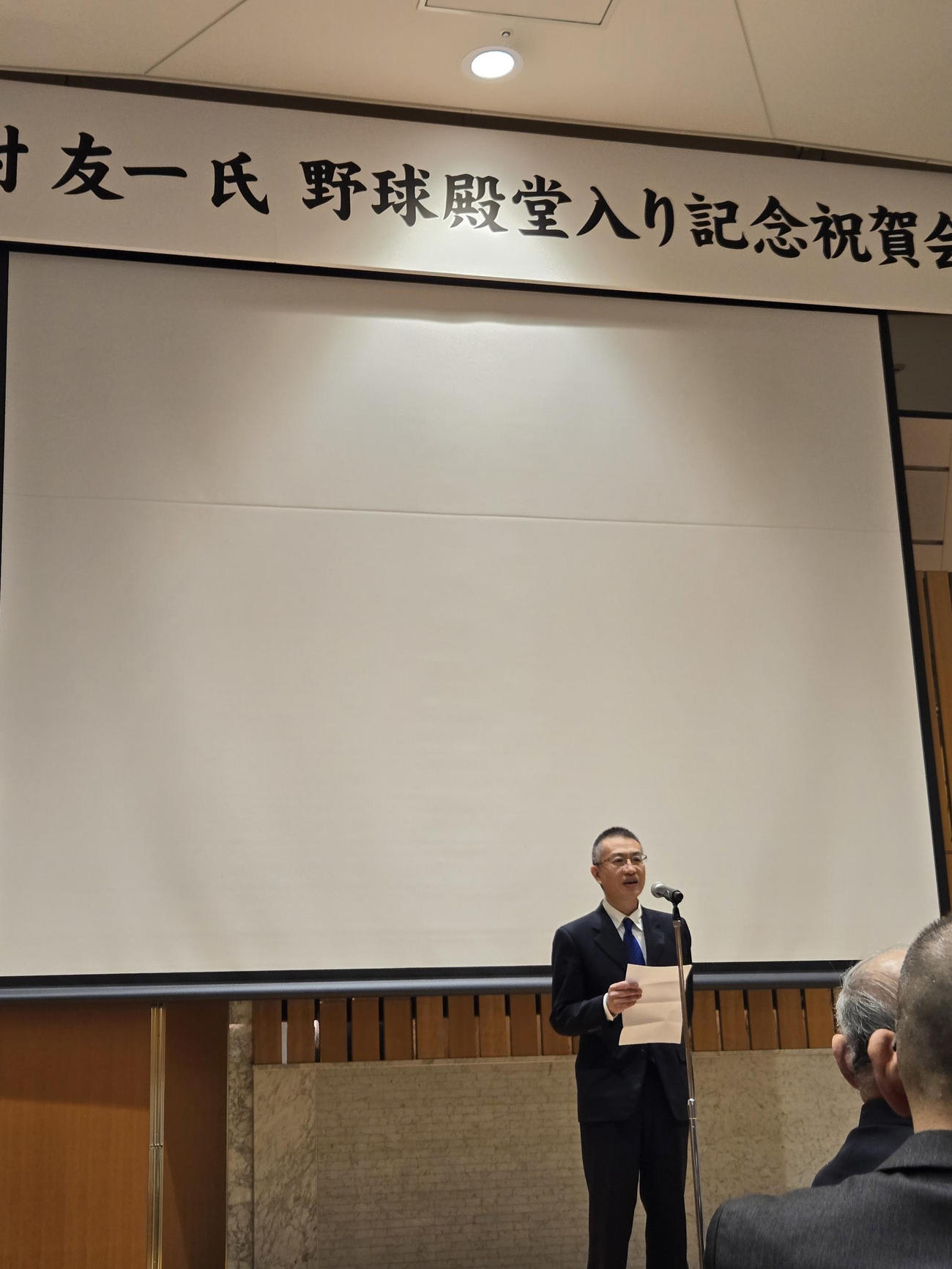 谷村友一氏の野球殿堂入り記念祝賀会で挨拶する野球殿堂博物館・庄司正信館長（撮影・寺尾博和）