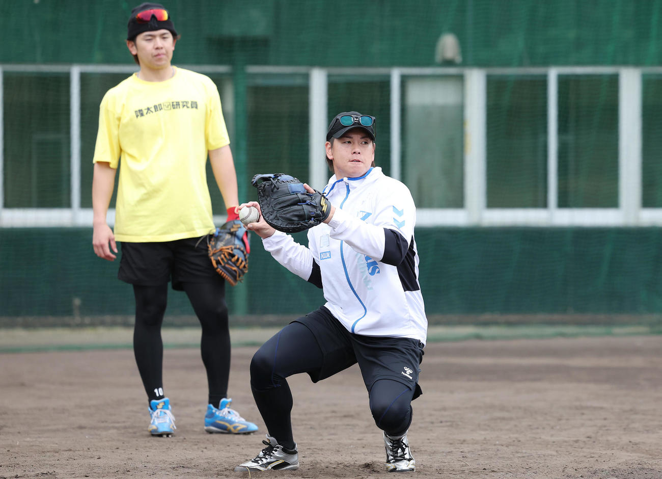 自主トレを公開し、送球練習を行う阪神梅野。左は日本ハム清水優（撮影・前田充）