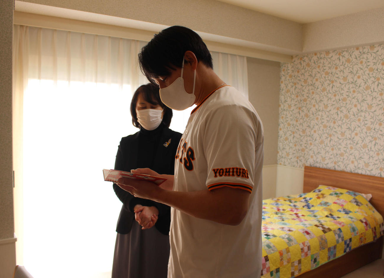 「ドナルド・マクドナルド・ハウス　せたがや」を訪問し、利用者のノートを読む巨人丸（撮影・久保賢吾）