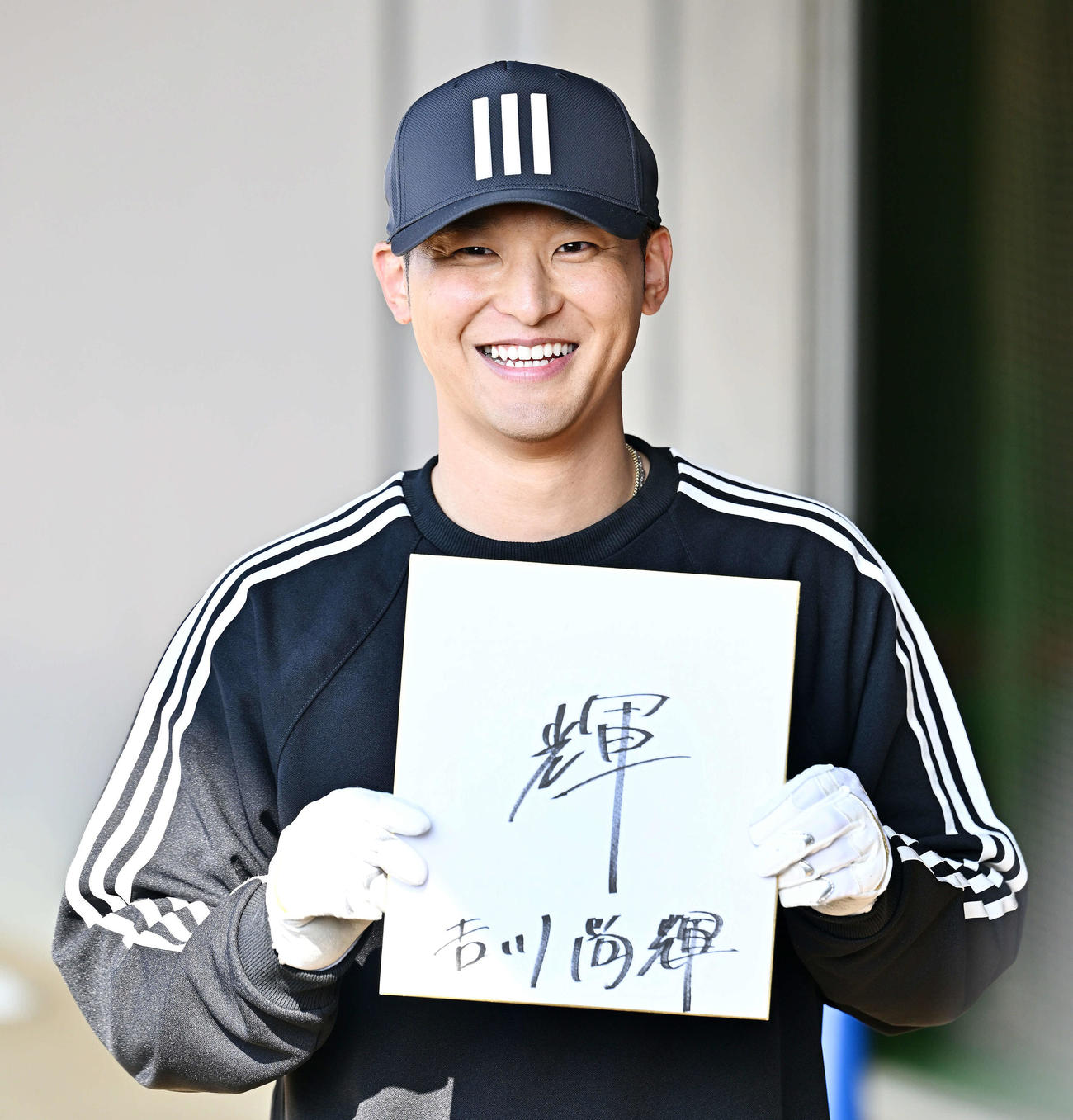 報道陣から今年の漢字を問われ「輝」と記した色紙を披露する巨人吉川（撮影・滝沢徹郎）