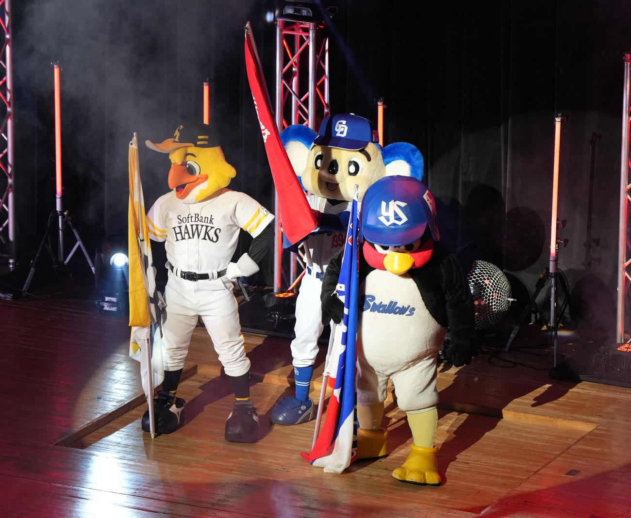ステージに登場し球団旗を手にする（左から）ハリーホーク、ドアラ、つば九郎（撮影・森本幸一）