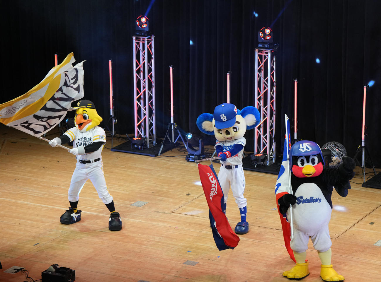ステージに登場し球団旗を振る（左から）ハリーホーク、ドアラ、つば九郎（撮影・森本幸一）