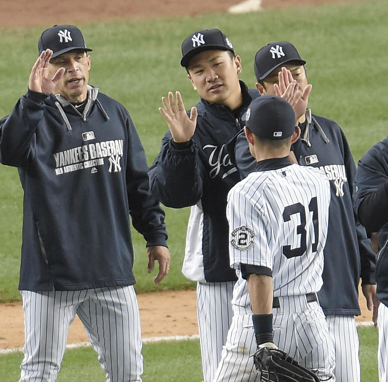 14年9月22日　ヤンキース対オリオールズ　オリオールズに勝利し、イチロー（右）をハイタッチで迎えるヤンキース田中将大。左はジョー・ジラルディ監督、右奥は黒田博樹