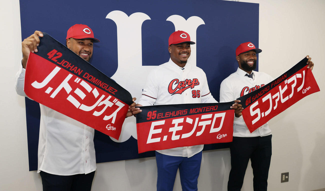 新外国人入団会見で、カープグッズの自身の名前が入ったタオルを手にする左からドミンゲス、モンテロ、ファビアン（撮影・加藤孝規）