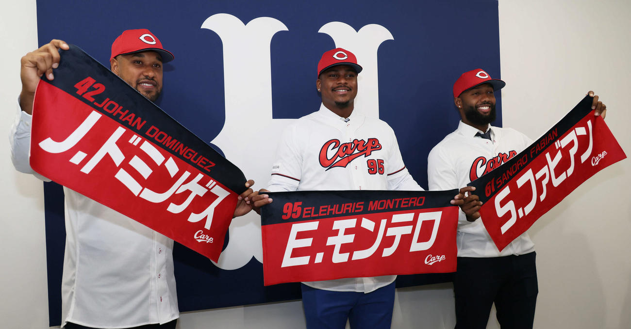 新外国人入団会見で、カープグッズの自身の名前が入ったタオルを手にする左からドミンゲス、モンテロ、ファビアン（撮影・加藤孝規）