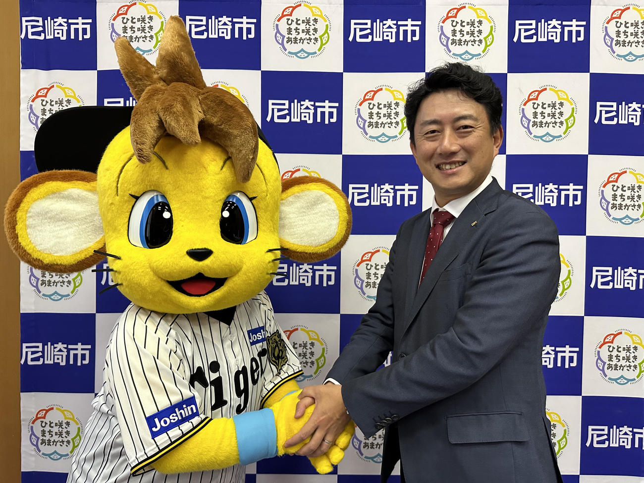 尼崎市役所を表敬訪問したコラッキーは尼崎市長の松本眞氏と写真に納まる（球団提供）