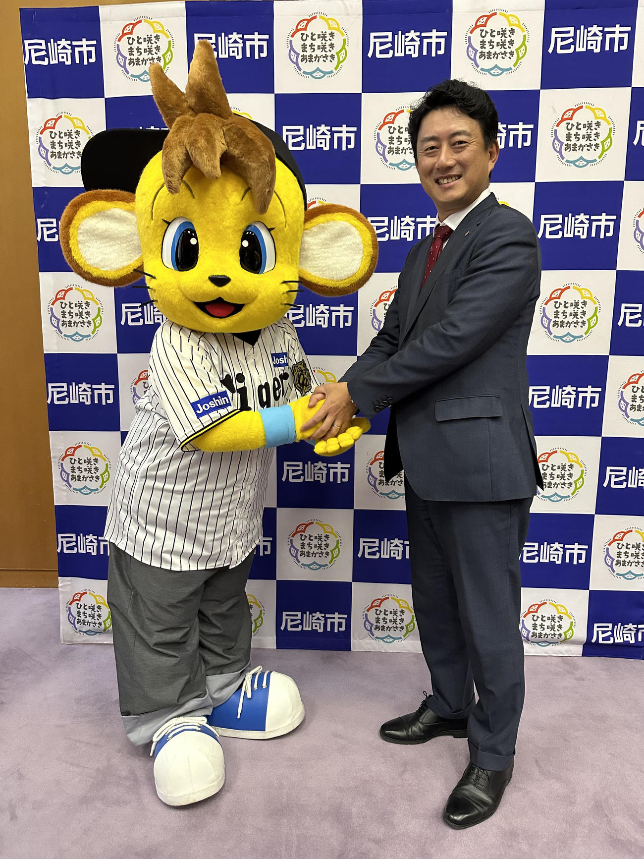 尼崎市役所を表敬訪問したコラッキーは尼崎市長の松本眞氏と写真に納まる（球団提供）