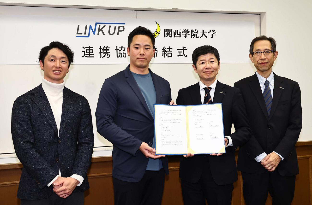 連携協力協定書にサインし笑顔を見せる左からLINK UP理事の近本（阪神タイガース）、石井代表理事、関西学院大学・森学長、古川副学長（撮影・上田博志）