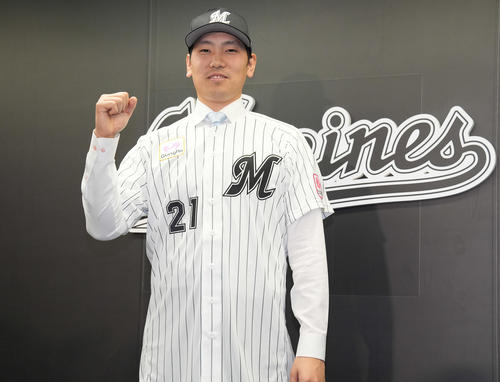 入団会見でユニホームを着てガッツポーズするロッテ石川柊（2024年12月19日）