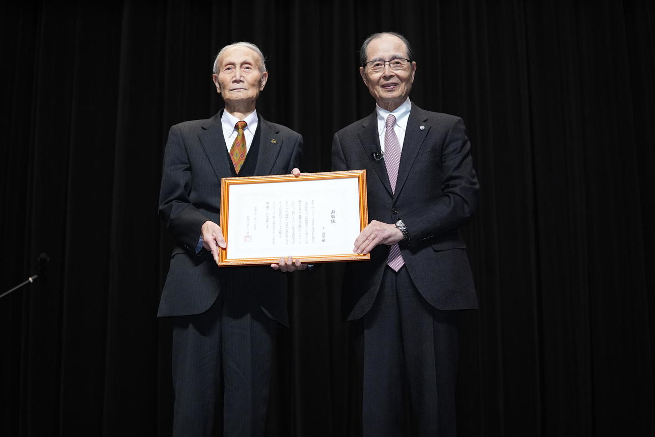 第15回日本スポーツ学会大賞授与で日本スポーツ学会笠原代表理事（左）と賞状を手に写真に納まる王氏（撮影・垰建太）