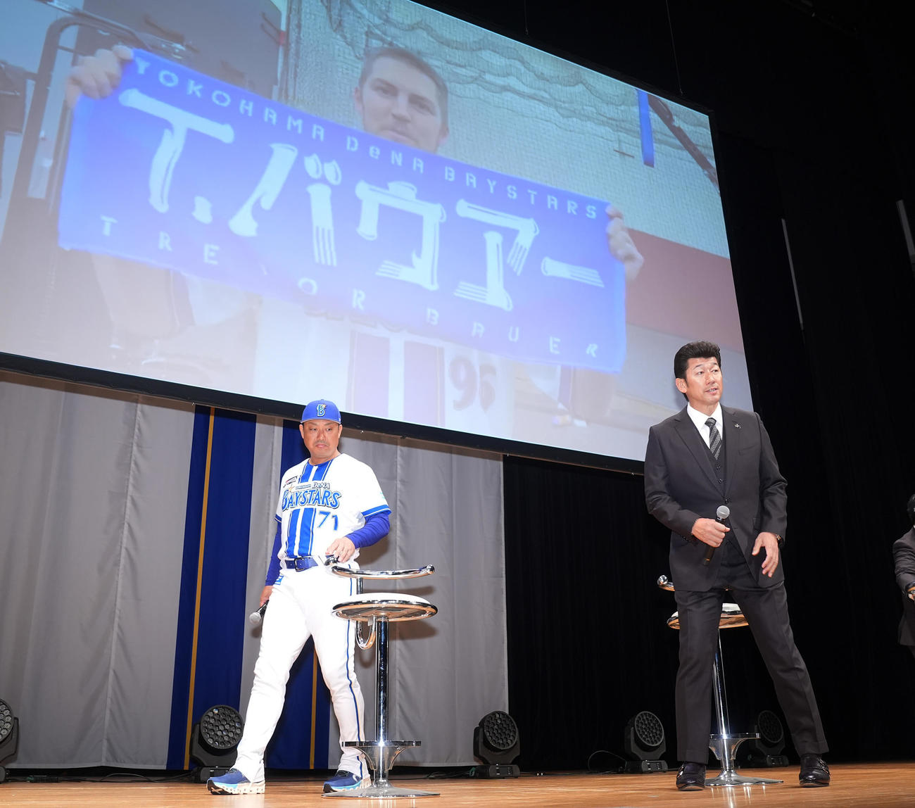 「横浜DeNAベイスターズ2025初春の集い」で入団が発表されたDeNAバウアーの映像を背に席につく三浦監督（右）と村田コーチ（撮影・垰建太）