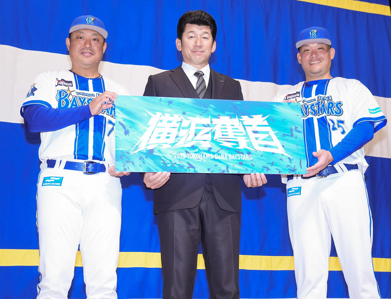 「横浜DeNAベイスターズ2025初春の集い」で2025年のスローガンを手に写真に納まるDeNA三浦監督（中央）、村田コーチ（左）、筒香（撮影・垰建太）