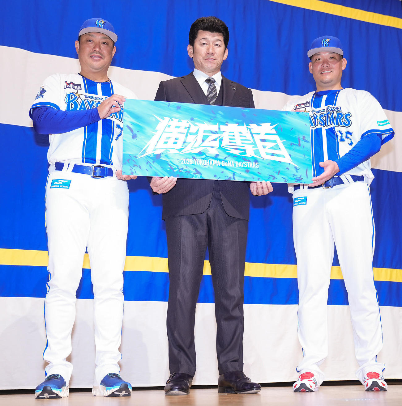 「横浜DeNAベイスターズ2025初春の集い」で2025年のスローガンを手に写真に納まるDeNA三浦監督（中央）、村田コーチ（左）、筒香（撮影・垰建太）