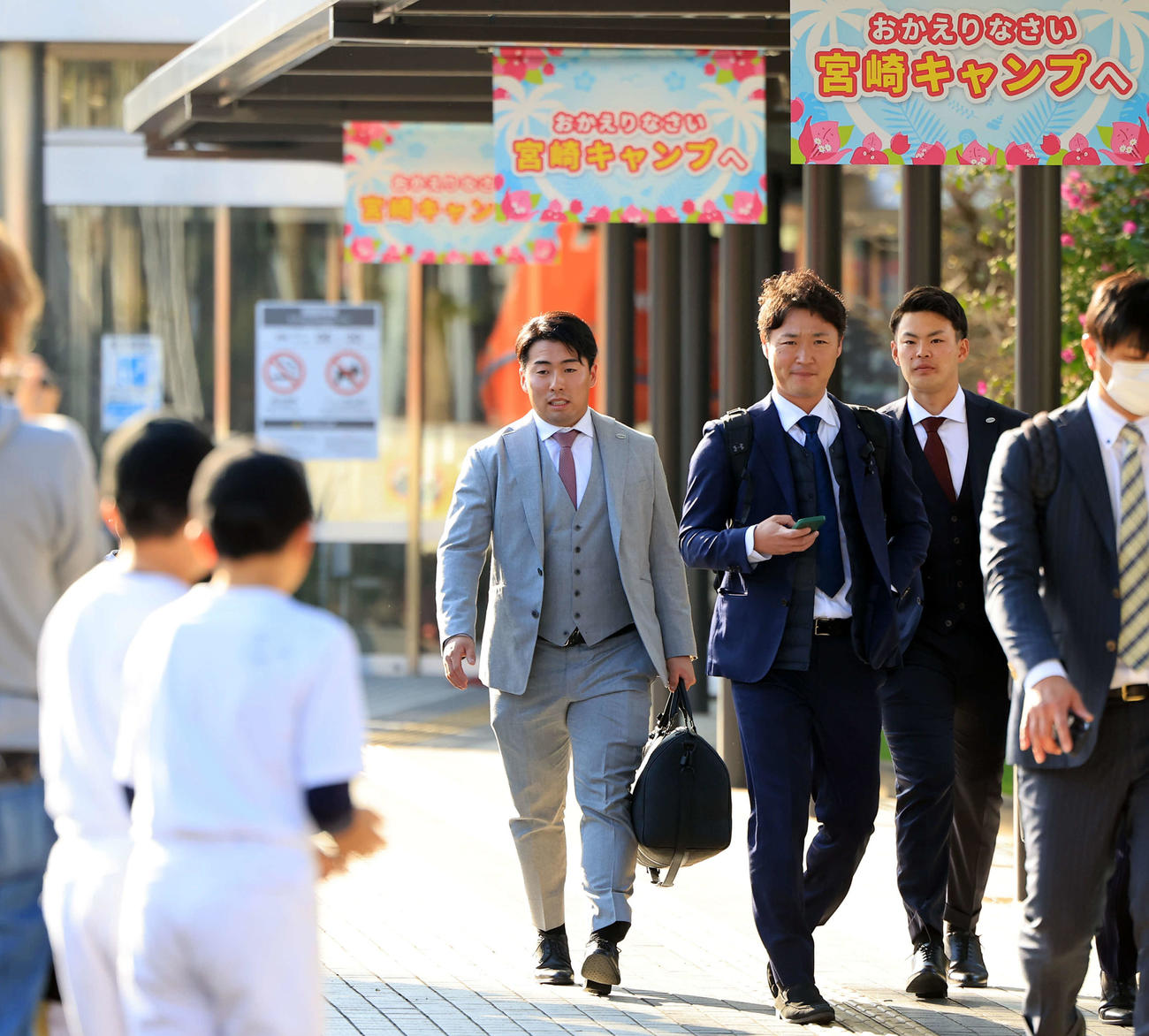 野球少年が見つめる中、合同自主トレのため宮崎入りした巨人浅野（左）と荒巻（右奥）（撮影・浅見桂子）