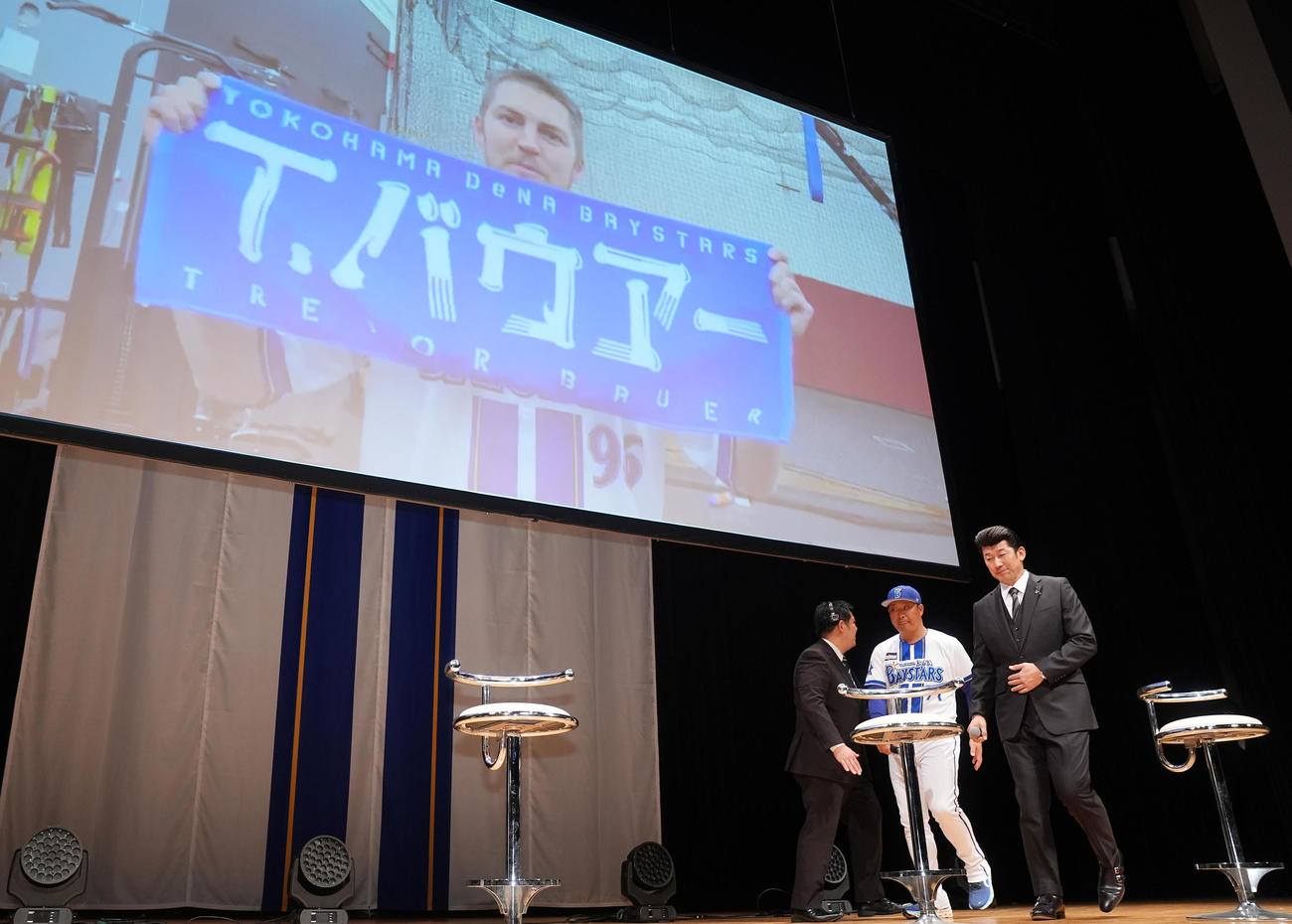 「横浜DeNAベイスターズ2025初春の集い」で入団が発表されたDeNAバウアーの映像を背に席につく三浦監督（右）と村田コーチ（撮影・垰建太）