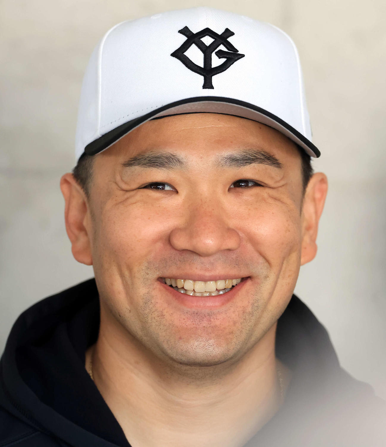 巨人の帽子をかぶり、報道陣の質問に笑顔を見せ田中将（撮影・浅見桂子）