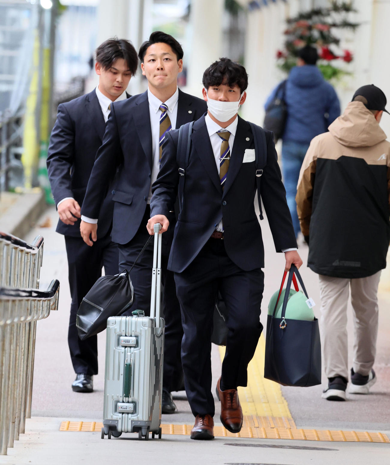 沖縄へ到着しバスへ向かう伊原。左端は野口、中央は木下（撮影・加藤哉）
