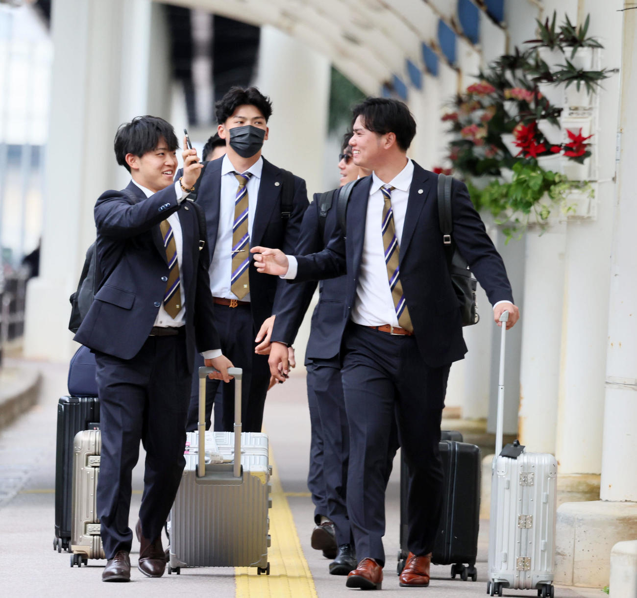 中川(左）は笑顔でスマホを川原に見せながらバスへ移動する。中央は井上（撮影・加藤哉）