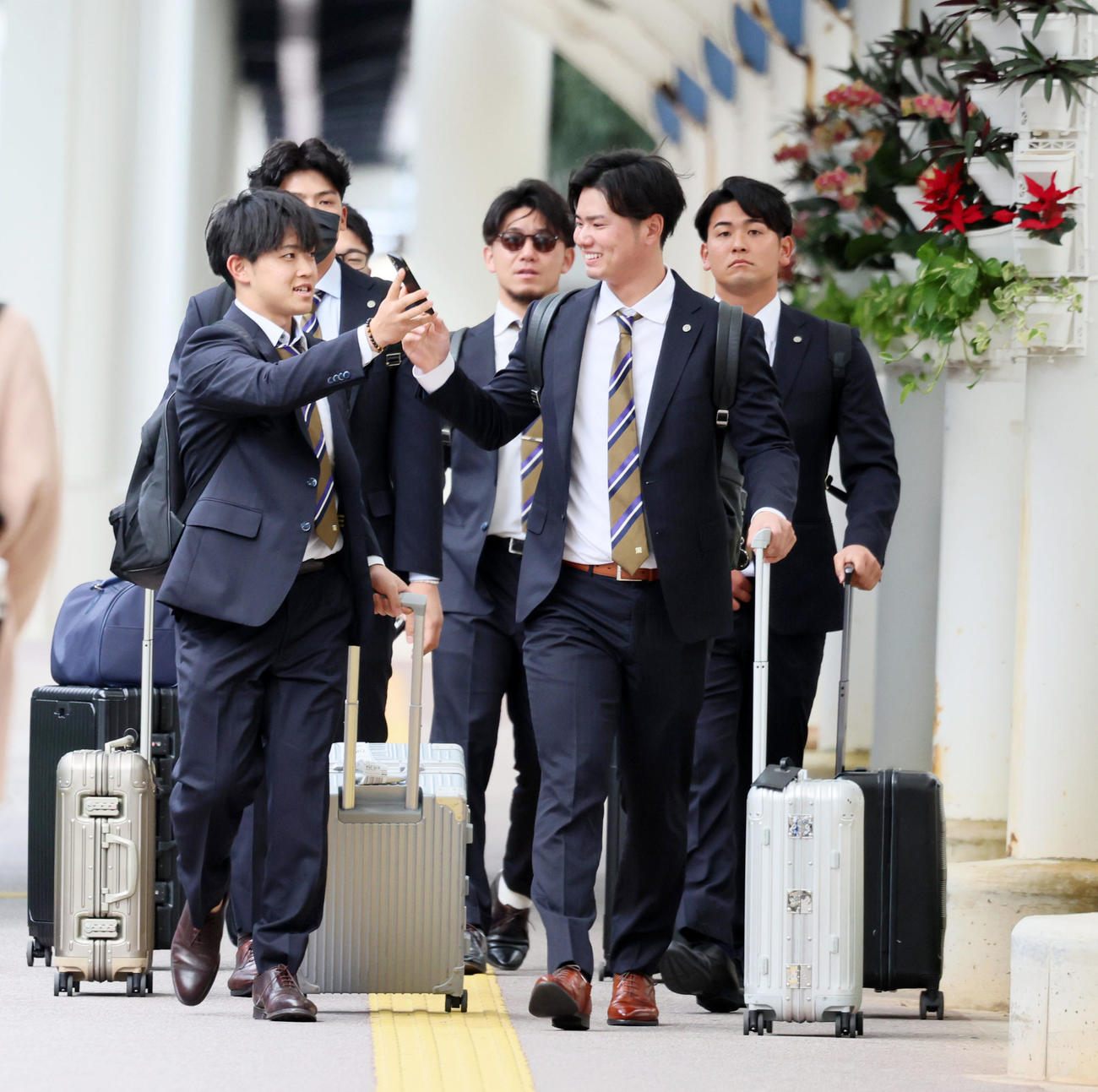 中川(左）は笑顔でスマホを川原に見せながらバスへ移動する。中央は伊藤将、右は岡留（撮影・加藤哉）