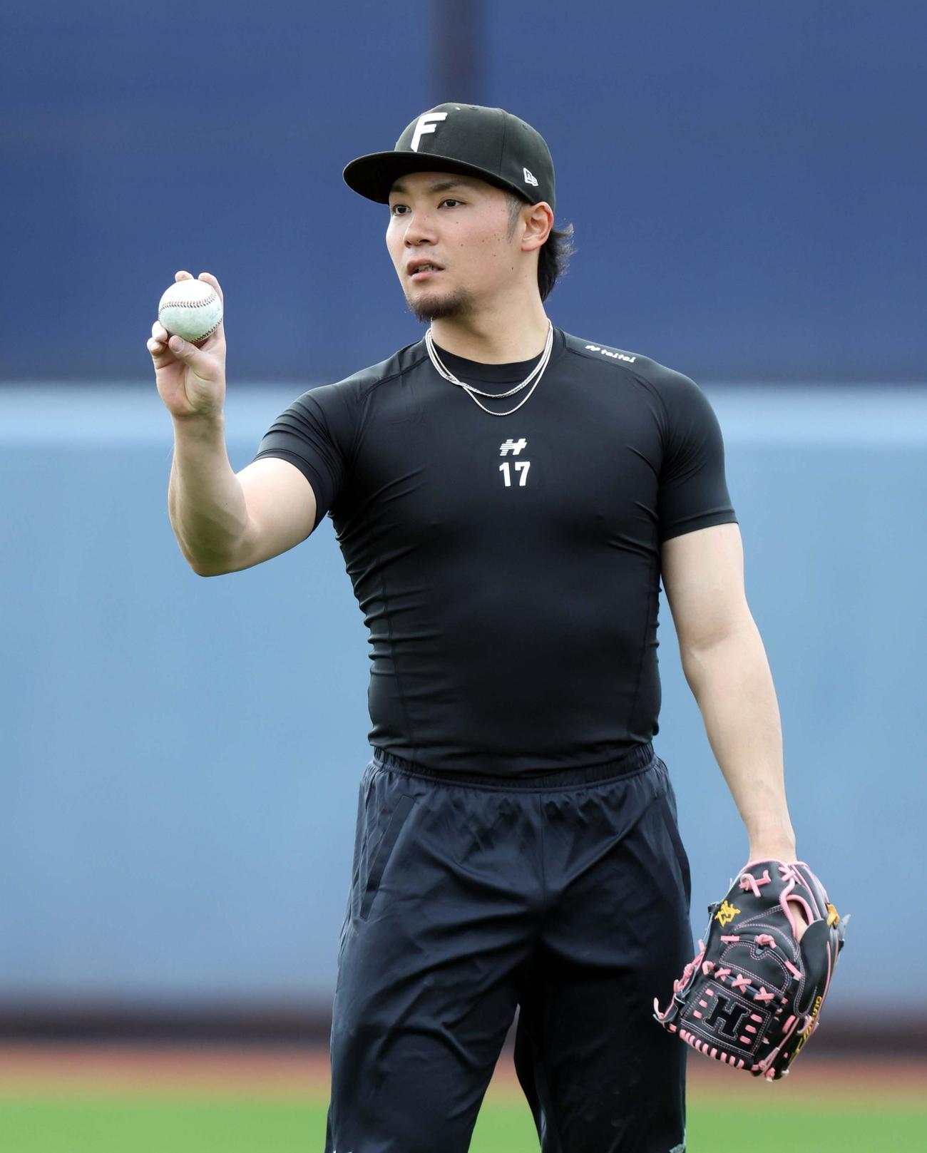 ボールの握りを確認しながらキャッチボールする日本ハム伊藤（撮影・黒川智章）