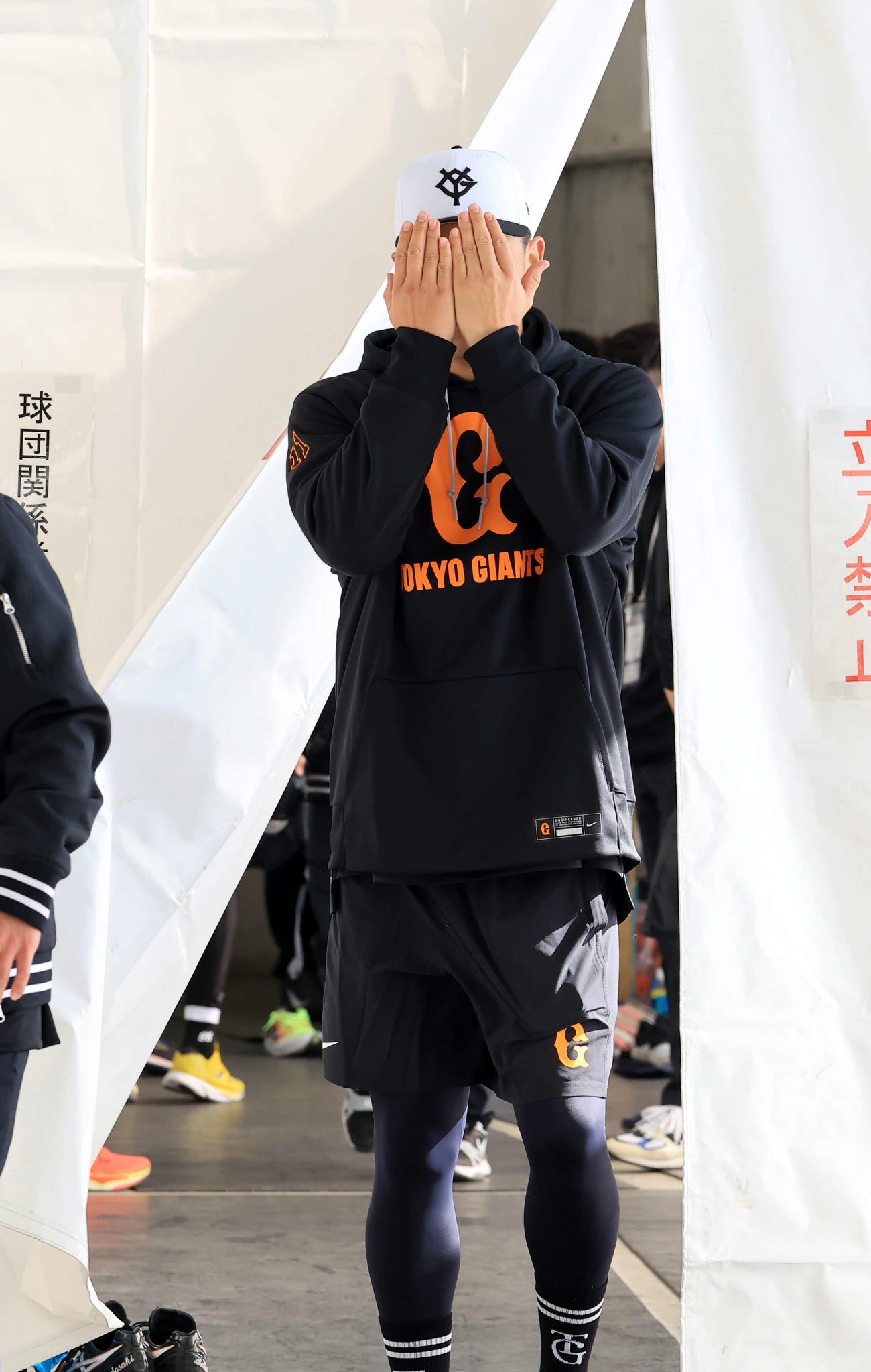 報道陣の囲み取材に出てきた巨人田中将は、両手で顔をかくしておどける（撮影・浅見桂子）