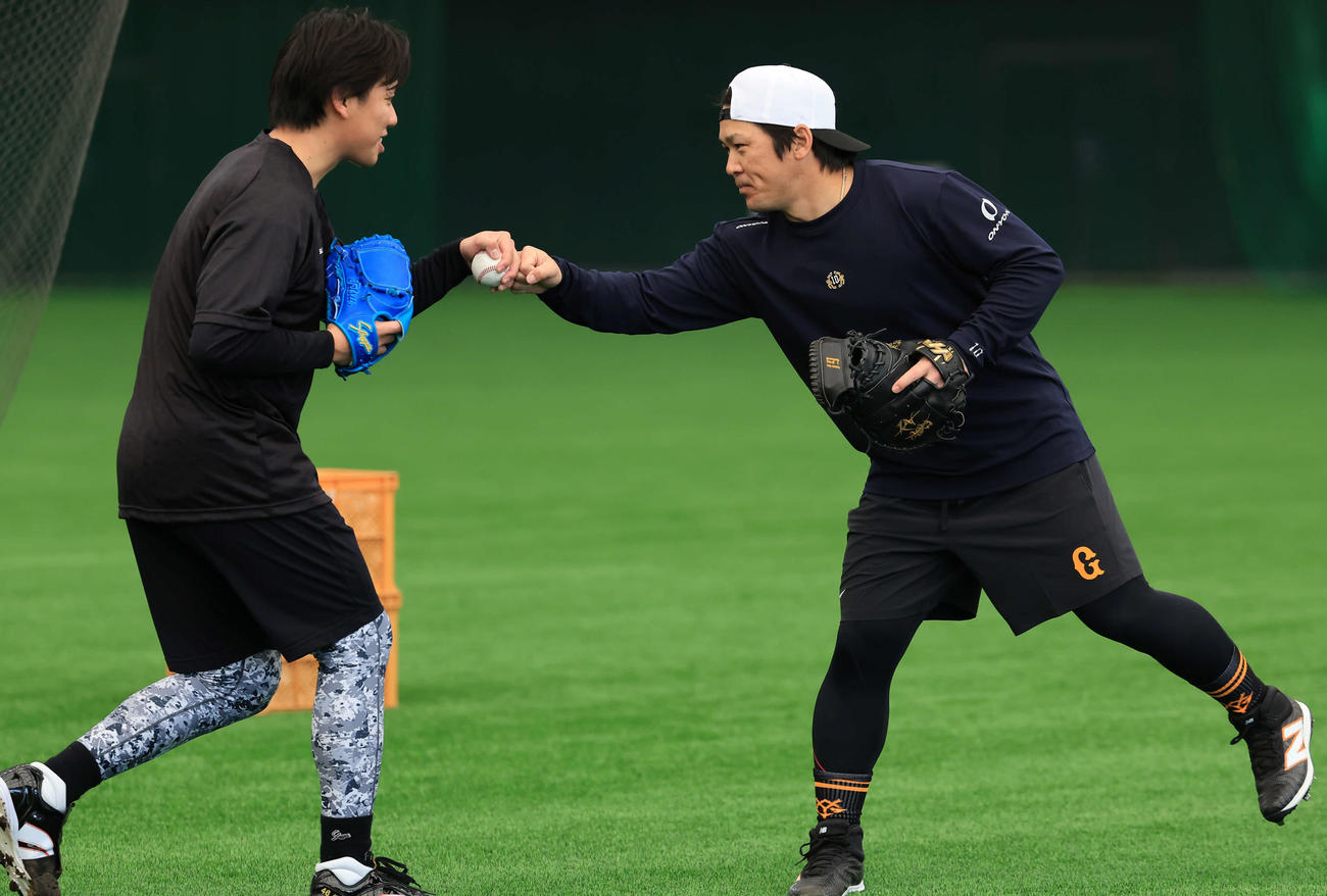 ブルペン投球を終えた巨人又木（左）とグータッチする甲斐（撮影・浅見桂子）