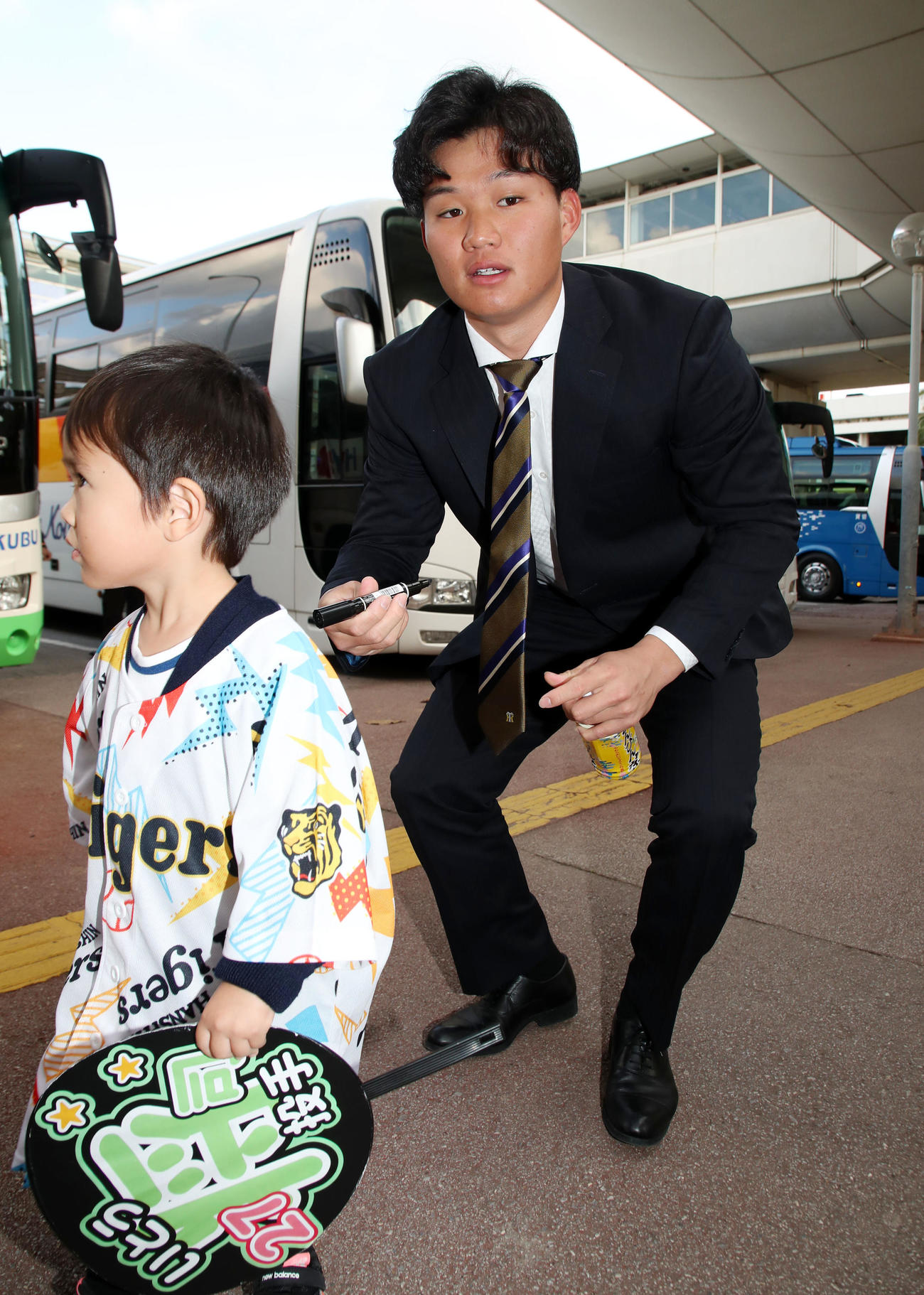 沖縄へ到着した阪神森下は、待っていた子供たちにサインする（撮影・加藤哉）