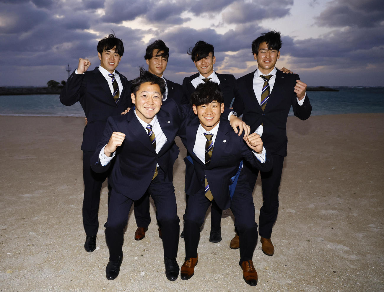 沖縄の宿舎前のビーチで笑顔を見せる、前列左から阪神木下、伊原、後列左から石黒、井坪、山田、高寺（撮影・藤尾明華）