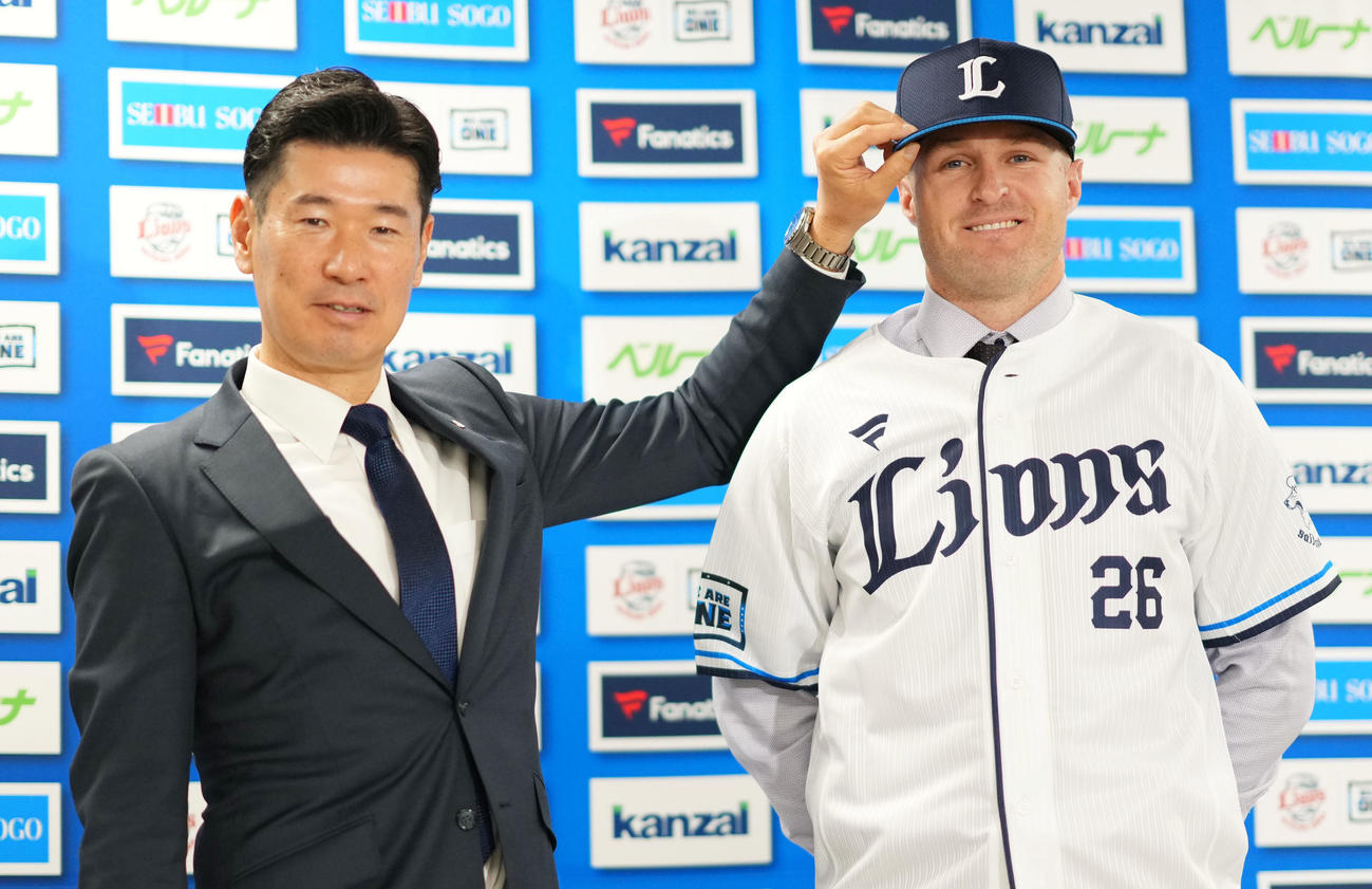 入団会見で笑顔を見せる西武タイラー・ネビン（右）と広池球団本部長（撮影・横山健太）