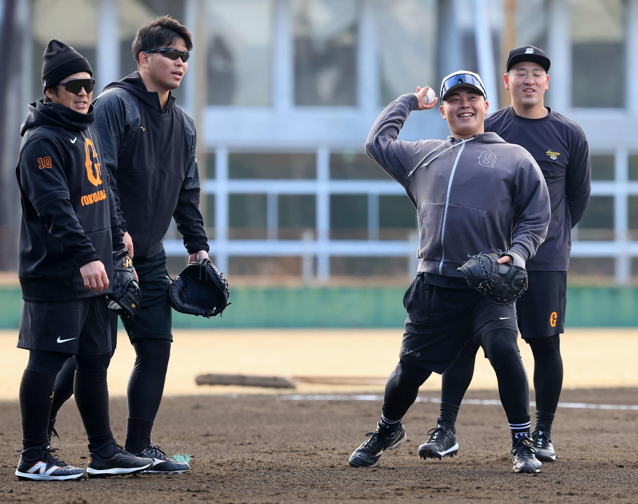 和気あいあいのムードでノックを受ける、左から巨人甲斐、大城卓、山瀬、岸田（撮影・浅見桂子）