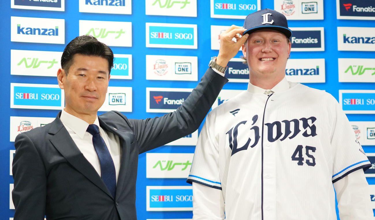 入団会見で笑顔を見せる西武トレイ・ウィンゲンター（右）と広池球団本部長（撮影・横山健太）